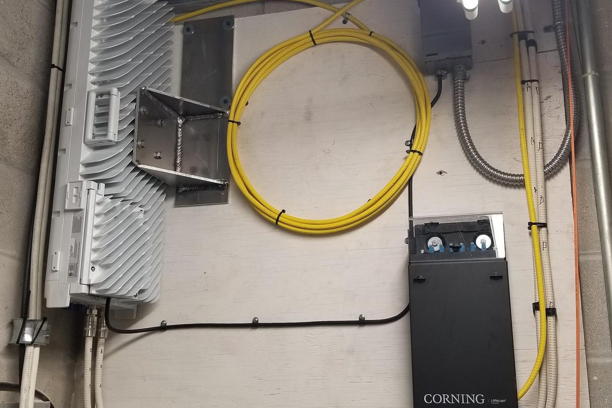 DAS remote unit and Corning fiber enclosure mounted in a convention center equipment room