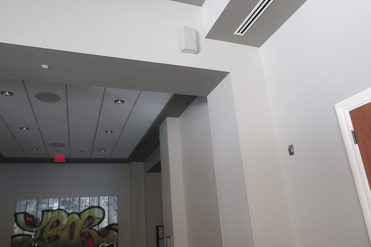 Ceiling-mounted DAS antenna providing wireless coverage in a hotel corridor and lobby