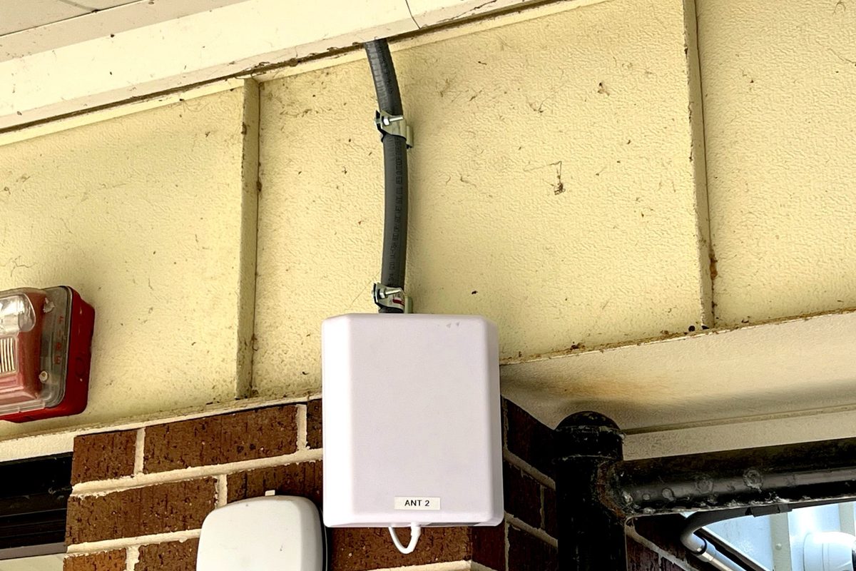 Exterior DAS antenna and wireless access point mounted at a school entrance